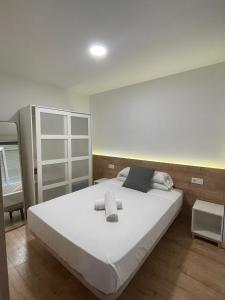 a bedroom with a large bed with white sheets at Pescadors Apartamentos TRG in Benidorm