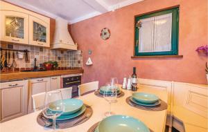 a kitchen with a table with plates and wine glasses at Cozy Home In Malinska With Wifi in Malinska
