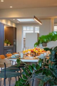 a table with plates of food and oranges on it at Unieke villa Catherine met frontaal zeezicht, parking sauna en strandcabine in De Panne