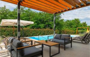 une terrasse avec des chaises et un parasol ainsi qu'une piscine dans l'établissement Villa Fritula, à Vižinada