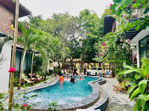 a pool at a resort with people in it at Tam Coc Boutique Garden in Ninh Binh