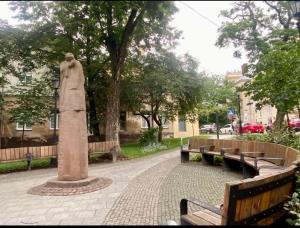 a statue of a woman sitting next to benches at St Benedict Apartments in Lviv
