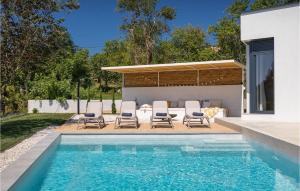 a swimming pool with chairs and a house at Villa Zel in Lovrinići