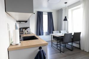 a kitchen with a sink and a table with chairs at Gammelbanken Seaview Suites - Modern Apartments with Sea View, Lofoten in Ballstad