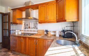 eine Küche mit Holzschränken und einer Spüle in der Unterkunft Gorgeous Home In Chiclana De La Fronter in Chiclana de la Frontera