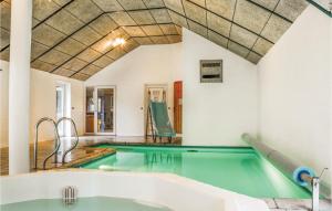 a swimming pool with a bath tub in a room at Amazing Home In Ringkøbing With Kitchen in Søndervig