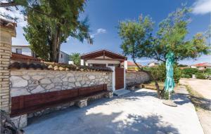 a brick fence with a stone retaining wall at Nice Home In Zdrelac With Sauna in Ždrelac