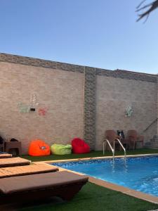 a swimming pool with colorful pillows next to a brick wall at King House in Sharm El Sheikh