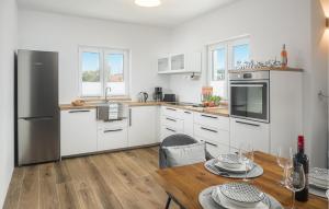 une cuisine avec des armoires blanches et une table en bois dans l'établissement Gorgeous Home In Rojci With Kitchen, à Kaštelir