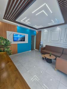 a lobby with a couch and a tv on a wall at Hotel Gutz in San Felipe de Puerto Plata
