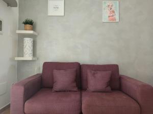 a purple couch with two pillows in a room at ross house in Fiumicino