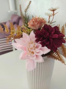 a white vase with a bunch of flowers in it at ross house in Fiumicino +20 photos