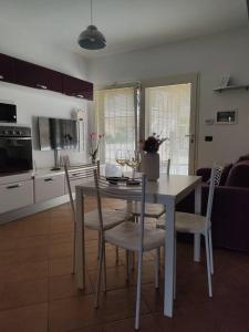 a kitchen and dining room with a table and chairs at ross house in Fiumicino