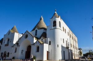 un grande edificio bianco con una torre dell'orologio di Trullo Relax ad Alberobello