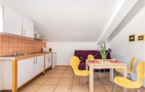 a kitchen with yellow chairs and a table at 1 Bedroom Cozy Apartment In Palit in Palit
