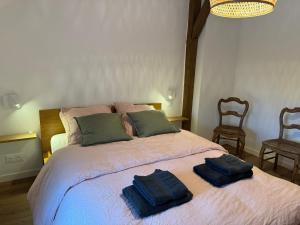 a bedroom with a bed with two towels on it at Évasion champêtre in Ambillou