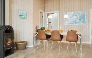 Un comedor con mesa y sillas y chimenea. en Holiday Home Sydmarken Hemmet Ii, en Falen