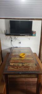 a wooden table with a bowl on top of it at Suíte o Pescador, praia do rosa in Garopaba