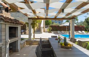 a patio with a table and chairs under a wooden pergola at Villa Marasi in Poreč