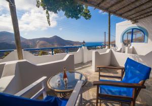 a patio with chairs and a table and a view of the ocean at Castelopetra in Katapola