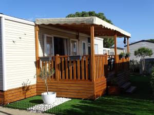 鲁西隆地区卡内Mobil home moderne neuf et ultra équipé de 6 à 8 couchages的小木屋设有1个带门廊的甲板