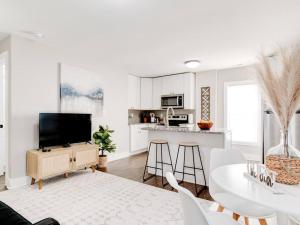 a white living room with a table and a kitchen at Cozy 1-Bedroom Retreat, New Remodel, Fast Wi-Fi in Columbus