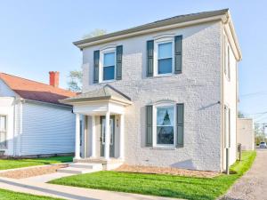 a white brick house with blue windows at Cozy 1-Bedroom Retreat, New Remodel, Fast Wi-Fi in Columbus