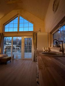 a kitchen with a sink and a large window at Relax House By The Stone in Nugariai