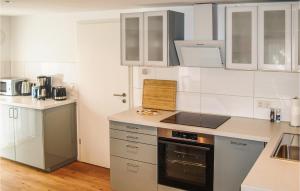 a kitchen with white cabinets and a stove top oven at Fewo Albrechtshof in Ribnitz-Damgarten