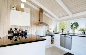 a kitchen with white cabinets and a counter top at Three-Bedroom Holiday Home In Sjallands Odde in Tjørneholm