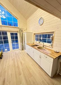 a kitchen with a sink and a clock on the wall at Relax House By The Stone in Nugariai