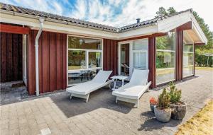 a patio with two white chairs and a table at Three-Bedroom Holiday Home In Sjallands Odde in Tjørneholm
