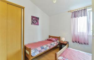 a small bedroom with two beds and a window at Lovely Apartment In Kustici With Wifi in Kustići