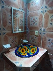 a bathroom with a sink with a flower plate on it at HOTEL ATLANTIDA in Playa del Carmen