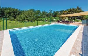 a swimming pool with blue water in a yard at Apartment Nedescina Brnjci in Santalezi