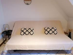 ein weißes Bett mit zwei Kissen darauf in der Unterkunft Studio Joseph 5 minutes Le Puy en Velay in Espaly-Saint-Marcel