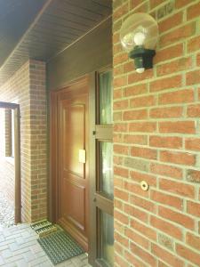 une maison en briques avec une porte et une lampe dans l'établissement Martha - Ferienhaus, 3 Schlafzimmer, 2 bis 6 Personen, S-Bahn nach Berlin, Strausseenähe, ruhige Lage, à Strausberg