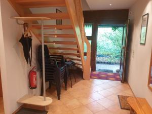 un escalier dans une pièce avec des chaises et une table dans l'établissement Martha - Ferienhaus, 3 Schlafzimmer, 2 bis 6 Personen, S-Bahn nach Berlin, Strausseenähe, ruhige Lage, à Strausberg