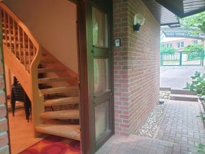 - un escalier en bois à côté d'un bâtiment en briques dans l'établissement Martha - Ferienhaus, 3 Schlafzimmer, 2 bis 6 Personen, S-Bahn nach Berlin, Strausseenähe, ruhige Lage, à Strausberg