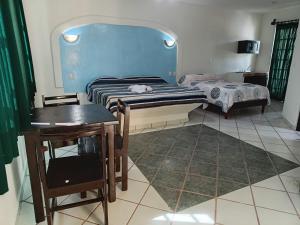 a bedroom with a bed and a desk and a table at HOTEL ATLANTIDA in Playa del Carmen