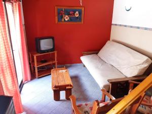 a room with a bed and a tv and a table at Duplex 7 Lunas in Villa Gesell
