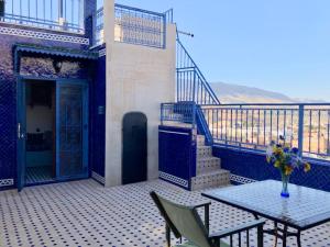 a balcony with a table and a staircase with a table and chairs at Riad d'Art de Fès in Fès al Bali