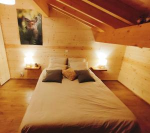 a large bed in a room with two lamps at Chalet bois Vieux Cerf 12 pers proche Centre Ville in Font-Romeu-Odeillo-Via