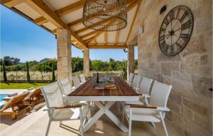 ウグリャンにあるVilla Golden Oliveの時計のあるパティオに置かれたダイニングテーブルと椅子
