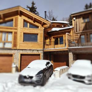 two cars parked in the snow in front of a house at Chalet bois Vieux Cerf 12 pers proche Centre Ville in Font-Romeu-Odeillo-Via