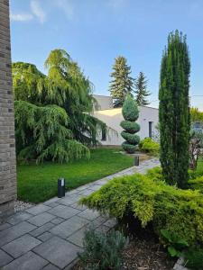 un jardín con un edificio y un árbol en Villa Kulacs, en Veľký Meder 71 fotos más