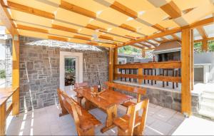 a patio with a wooden table and chairs at 2 Bedroom Gorgeous Home In Smokvica in Smokvica +41 photos