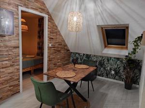 een eetkamer met een tafel en groene stoelen bij L'Obernai in Obernai
