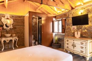 a bedroom with a bed and a tv on a wall at Refúgios da Natureza in Entre -os- Rios