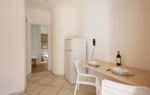 małą kuchnię ze stołem i lodówką w obiekcie Pet Friendly Apartment In Ricadi w mieście Ricadi